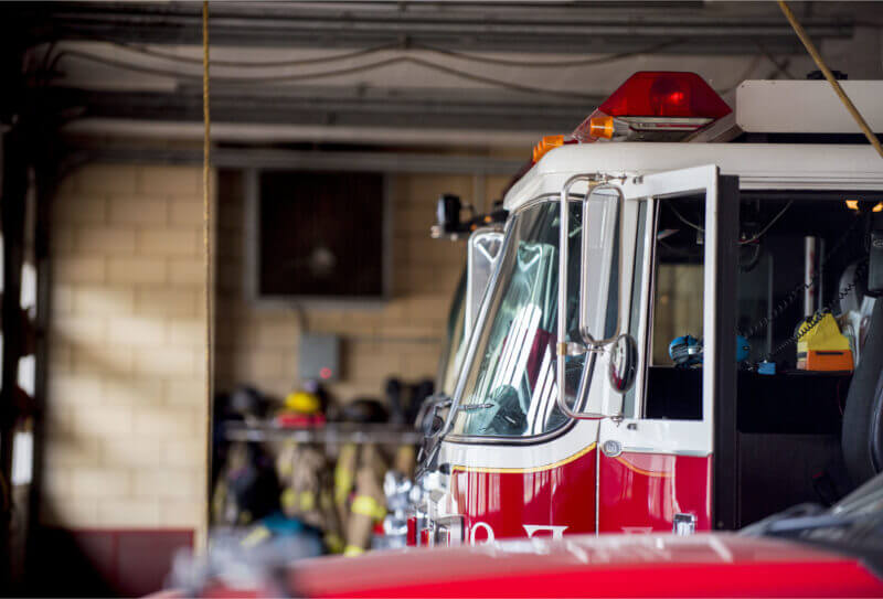 A fire truck parked inside a spacious garage, ready for emergency response.