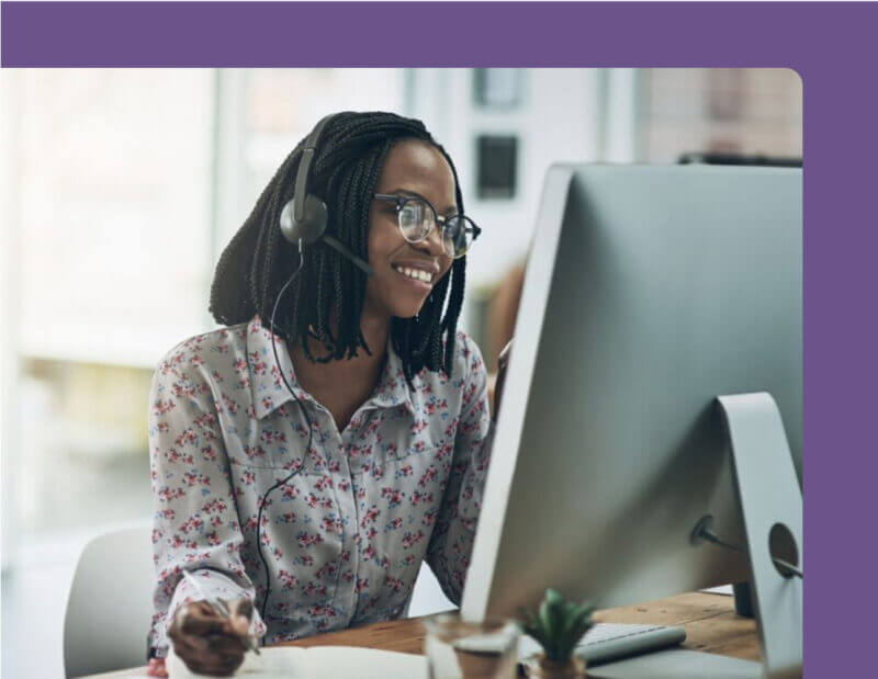 A call center agent efficiently assisting customers while working from home, surrounded by a computer and headset.