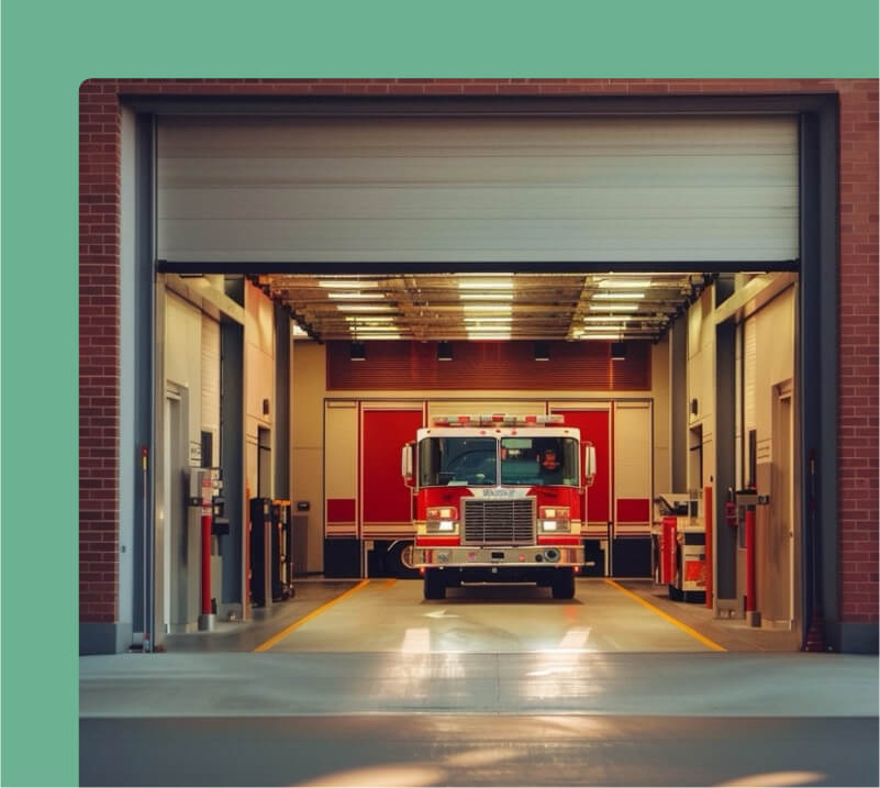 A fire truck parked inside a spacious garage, ready for emergency response.